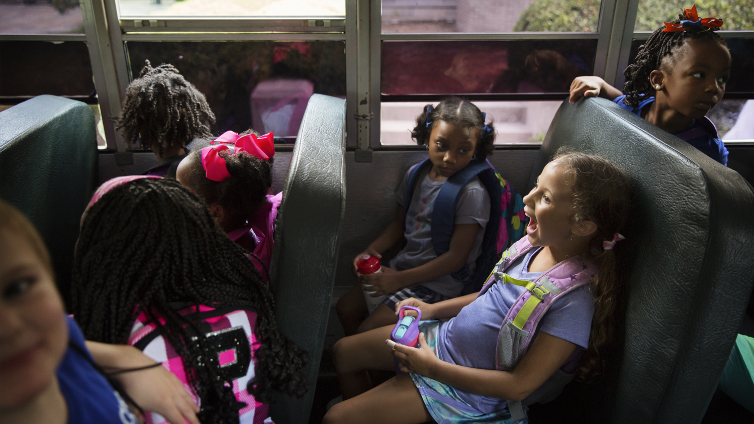 Bricolage Academy students sit on the bus together. The school is being hailed as an example of innovation by people on all sides of the charter debate.