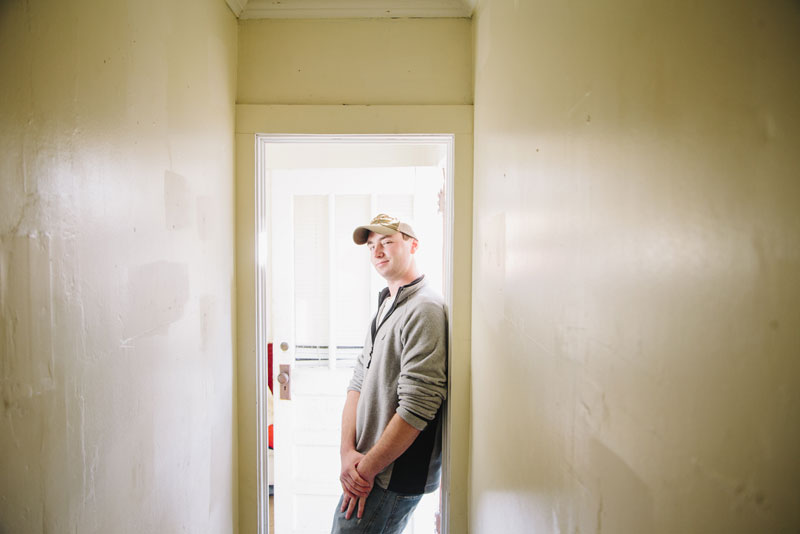 Dane Mitchell stands in the hallway of his home